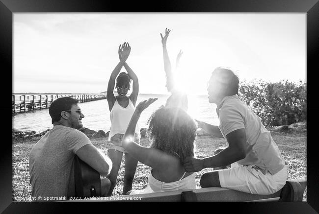Friends dancing to guitar music outdoors at sunset Framed Print by Spotmatik 
