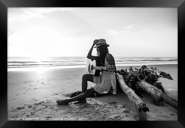 Indian female sitting on driftwood with ocean sunrise Framed Print by Spotmatik 