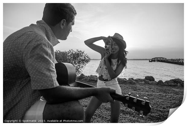 Smiling female taking photograph of partner playing guitar Print by Spotmatik 