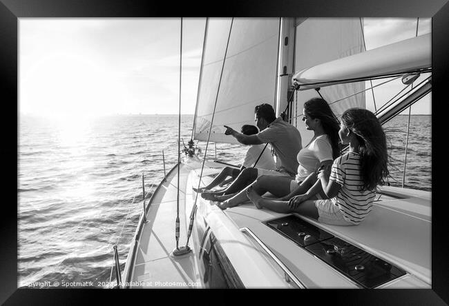 Relaxed family on luxury yacht sailing towards sunset Framed Print by Spotmatik 