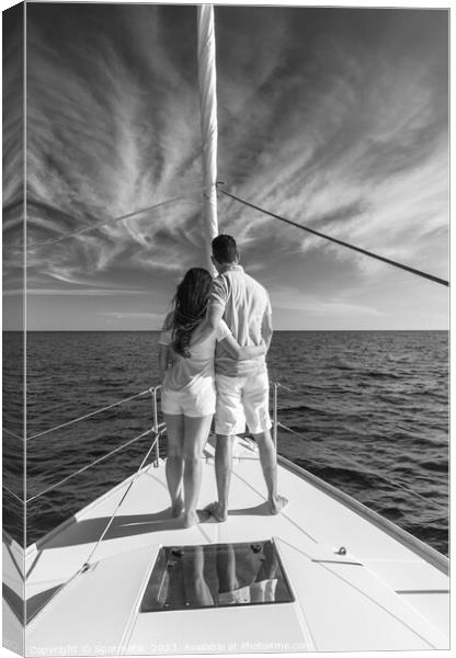 Loving young Latino couple standing on luxury yacht Canvas Print by Spotmatik 