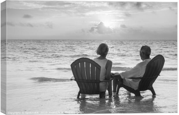 Retired couple enjoying sunset view over ocean Bahamas Canvas Print by Spotmatik 
