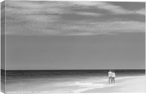 Retired couple walking barefoot by turquoise ocean Bahamas Canvas Print by Spotmatik 