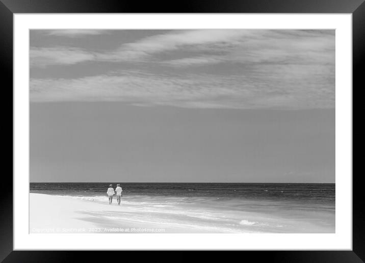 Mature couple walking along shoreline at beach resort Framed Mounted Print by Spotmatik 