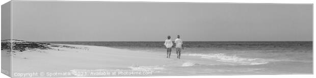 Panoramic view mature couple walking on beach Bahamas Canvas Print by Spotmatik 