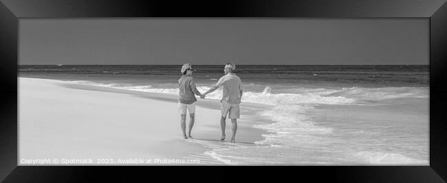 Panoramic beach view with retired couple holding hands Framed Print by Spotmatik 