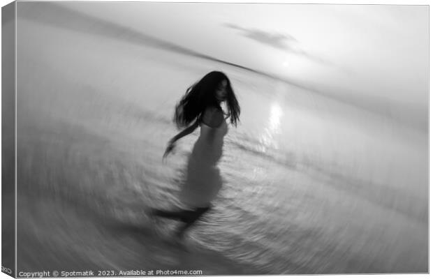 Motion blurred Asian girl dancing in ocean sunset Canvas Print by Spotmatik 