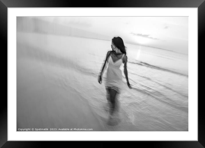 Motion blurred woman walking through waves at sunset Framed Mounted Print by Spotmatik 