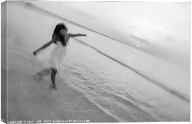 Motion blur carefree Asian female dancing on shoreline Canvas Print by Spotmatik 