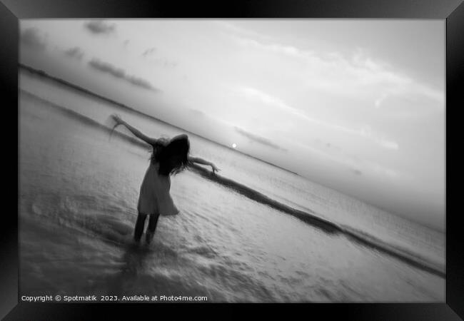 Motion blur girl standing in ocean at sunrise Framed Print by Spotmatik 