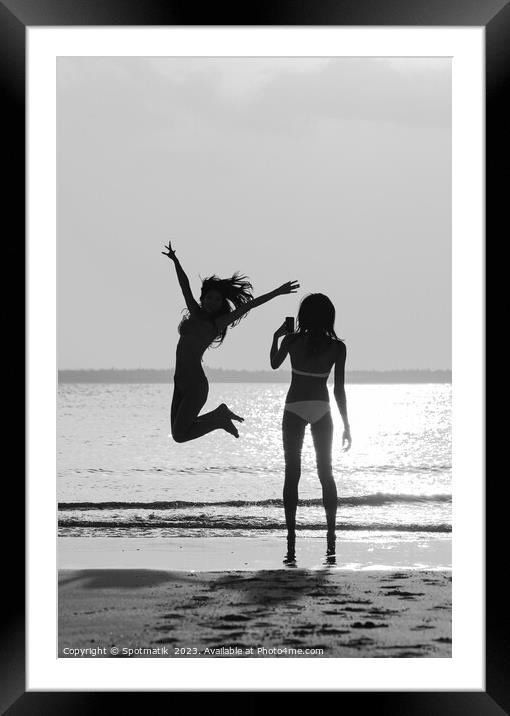 Tropical ocean sunrise with girl photographing friend jumping Framed Mounted Print by Spotmatik 
