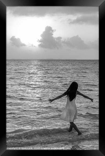 Asian female dancing in ocean waves at sunrise Framed Print by Spotmatik 