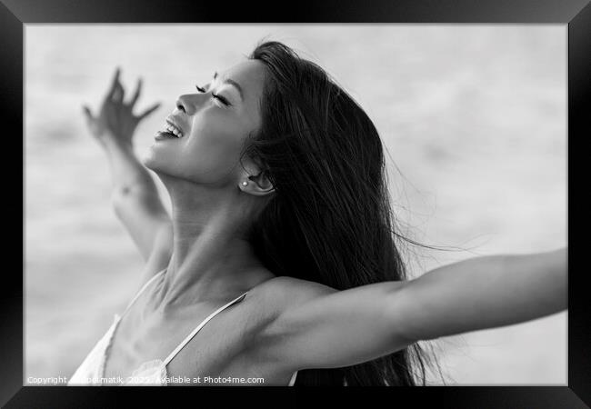 Asian girl enjoying freedom outdoors by the ocean Framed Print by Spotmatik 