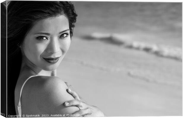 Portrait of smiling Asian woman by ocean waves Canvas Print by Spotmatik 
