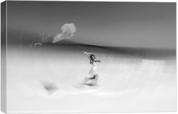 Motion blurred young woman flying kite on beach Canvas Print by Spotmatik 