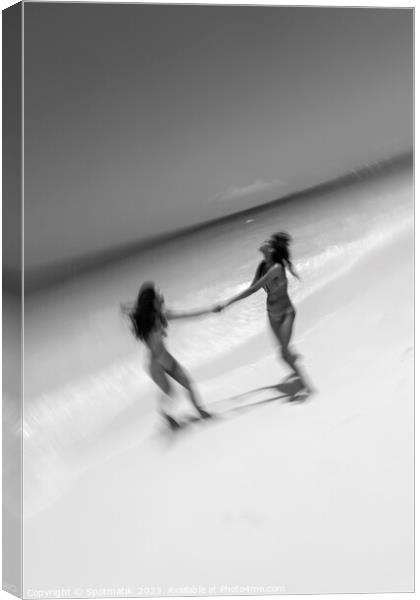 Motion blurred women in swimwear playing by ocean Canvas Print by Spotmatik 