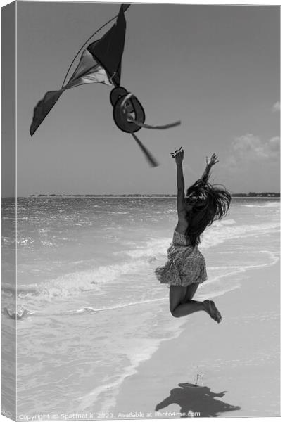 Happy Asian girl jumping by ocean flying kite Canvas Print by Spotmatik 