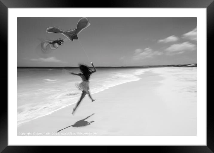 Motion blurred woman jumping on beach flying kite Framed Mounted Print by Spotmatik 