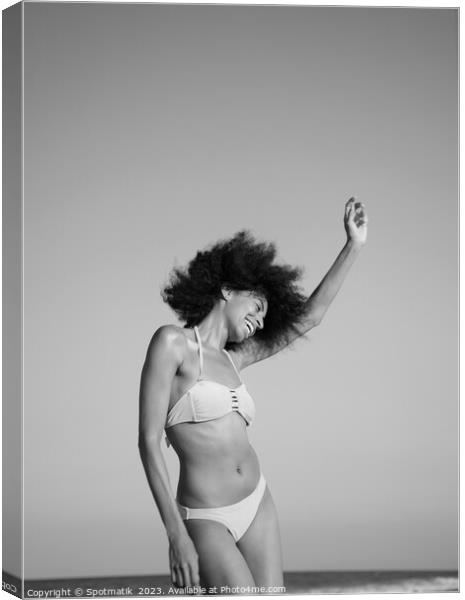 Afro girl in swimwear dancing on the beach Canvas Print by Spotmatik 
