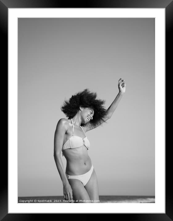 Afro girl in swimwear dancing on the beach Framed Mounted Print by Spotmatik 