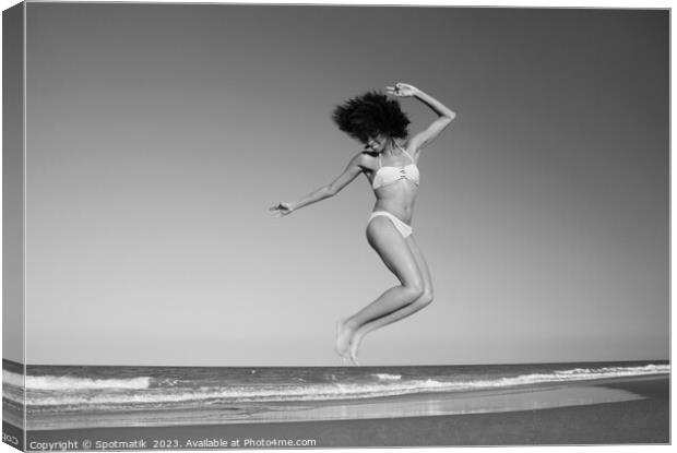 Afro American woman jumping for joy on beach Canvas Print by Spotmatik 