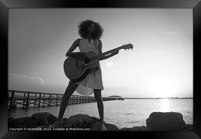 Young African American woman playing guitar at sunrise Framed Print by Spotmatik 