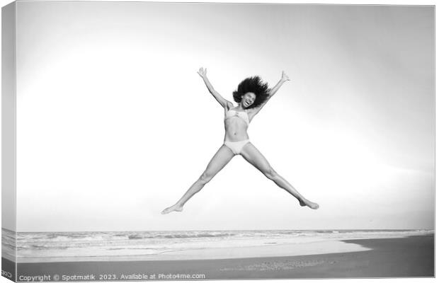Healthy African American girl jumping high on beach Canvas Print by Spotmatik 