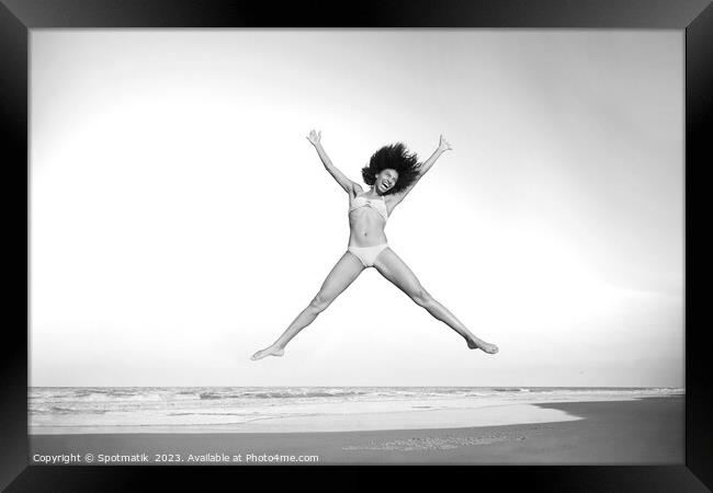 Healthy African American girl jumping high on beach Framed Print by Spotmatik 