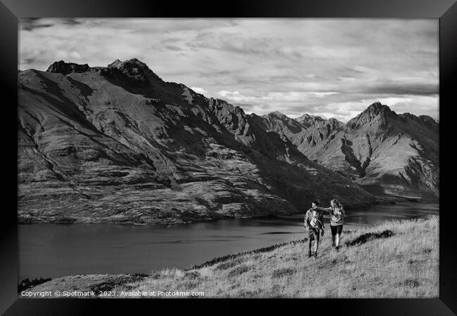 Hikers on trekking expedition enjoying view Lake Wakatipu  Framed Print by Spotmatik 
