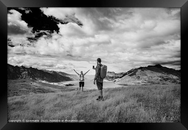 Successful young couple taking smartphone picture Lake Wakatipu  Framed Print by Spotmatik 