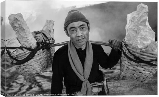 Indonesian worker manually carrying sulphur blocks from volcano  Canvas Print by Spotmatik 
