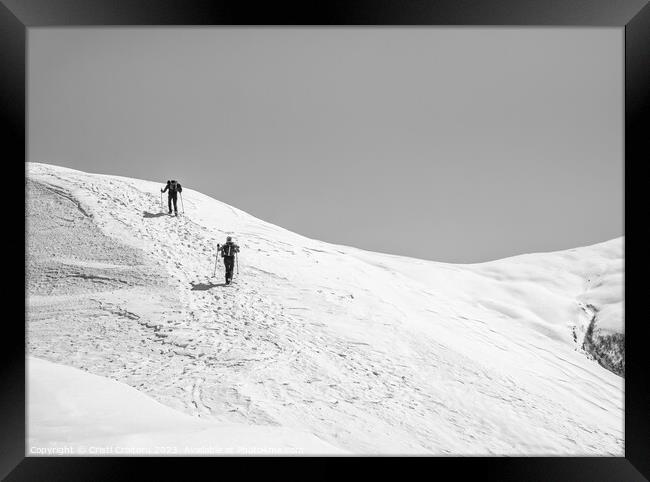 Two Hikers on a trail walking through snow. Winter landscape in Carapathian Mountains, Romania. Framed Print by Cristi Croitoru