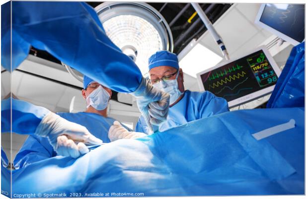 Caucasian surgical team wearing scrub operating on patient Canvas Print by Spotmatik 