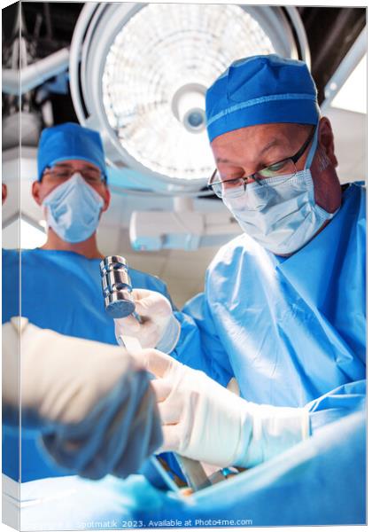 Medical surgeon operating on patient under overhead light Canvas Print by Spotmatik 