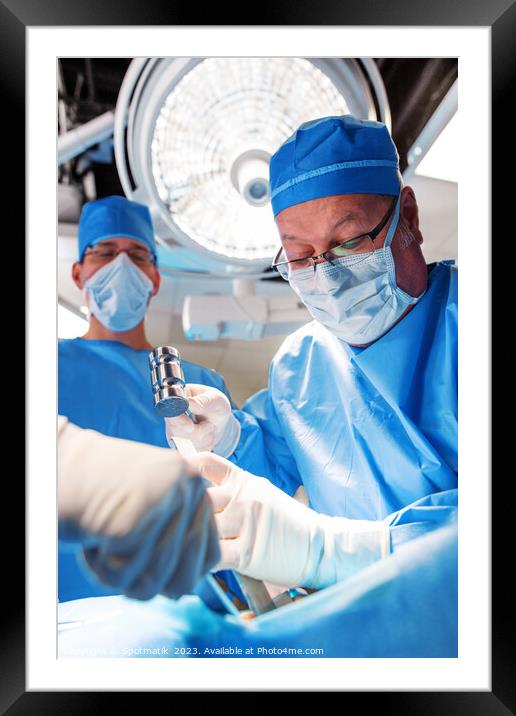 Medical surgeon operating on patient under overhead light Framed Mounted Print by Spotmatik 