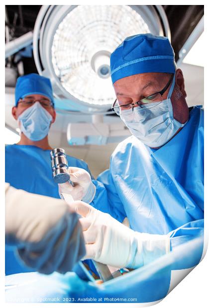 Medical surgeon operating on patient under overhead light Print by Spotmatik 