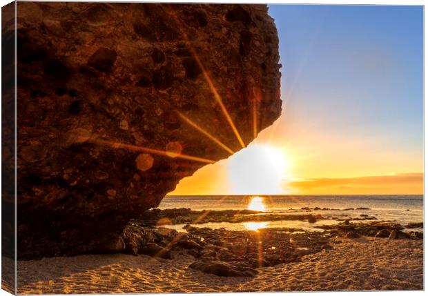 Photography with the sunrise sun behind the rock of the beach of the dead Canvas Print by Vicen Photo