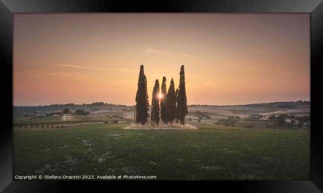 Sunset landscape in Alta Maremma. Rolling hills and cypress trees Framed Print by Stefano Orazzini