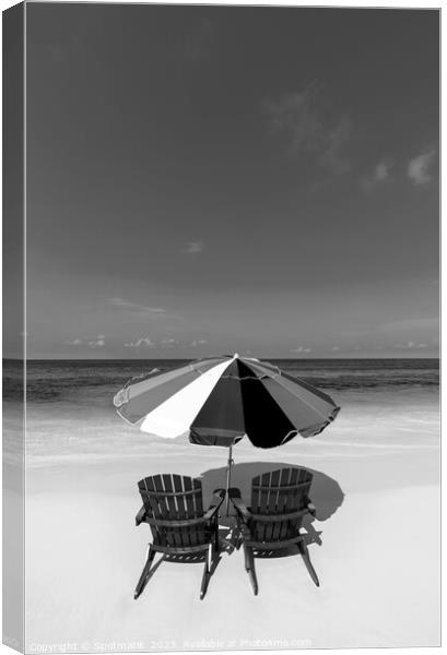 Bahamas beach umbrella and chairs on sandy beach  Canvas Print by Spotmatik 