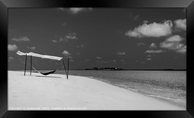 Hammock swaying in the breeze over white sands  Framed Print by Spotmatik 