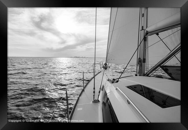 Sailing private yacht towards city skyline at sunrise Framed Print by Spotmatik 