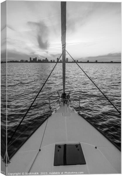 Bow of yacht sailing towards cityscape at sunrise Canvas Print by Spotmatik 