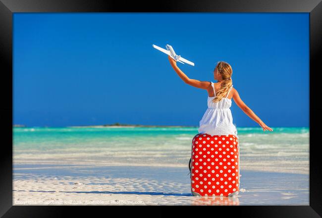 Girl sitting on red travel luggage on beach plane Framed Print by Spotmatik 
