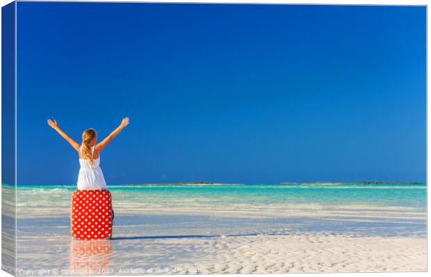 Blonde girl having beach fun sitting on suitcase Canvas Print by Spotmatik 