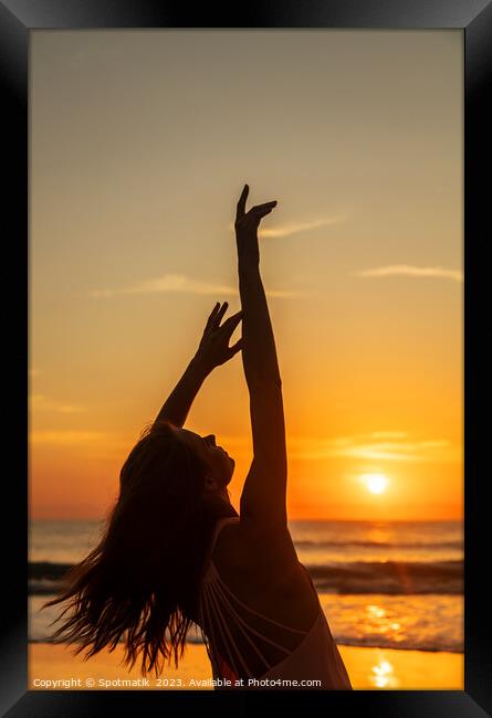 Bohemian girl enjoying carefree lifestyle dancing on beach Framed Print by Spotmatik 