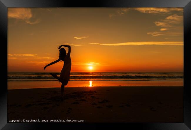 Happy young girl dancing on beach at sunset Framed Print by Spotmatik 