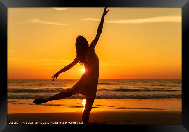 Sunset view carefree young girl dancing on beach Framed Print by Spotmatik 
