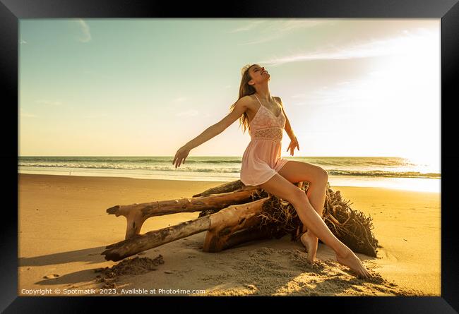Young Caucasian girl enjoying sun sitting on driftwood  Framed Print by Spotmatik 