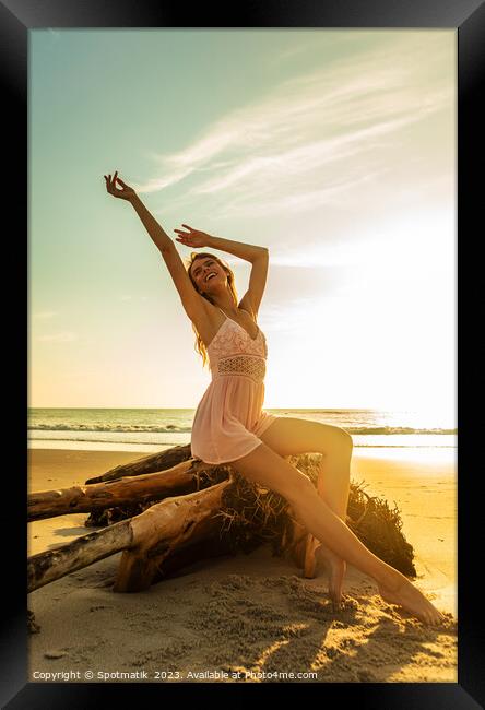 Carefree Bohemian girl sitting on driftwood at sunset Framed Print by Spotmatik 