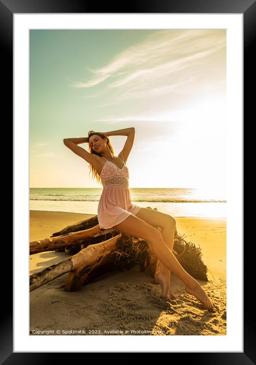 Young Bohemian girl posing on driftwood at sunset Framed Mounted Print by Spotmatik 